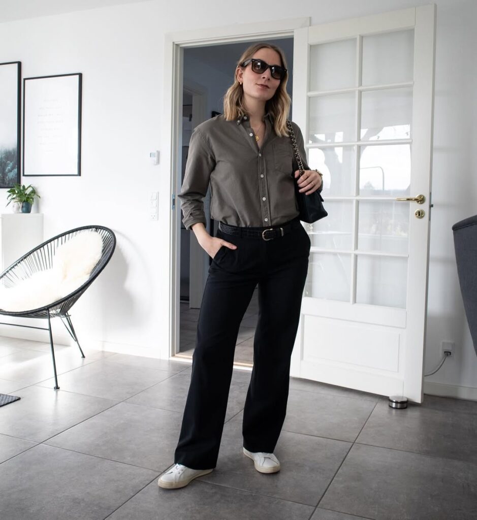 Woman in olive shirt, black trousers, and white sneakers – casual office outfit with classic pieces