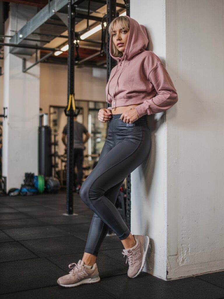 Dusty rose cropped hoodie, high-waisted black leggings, taupe New Balance 574s. 