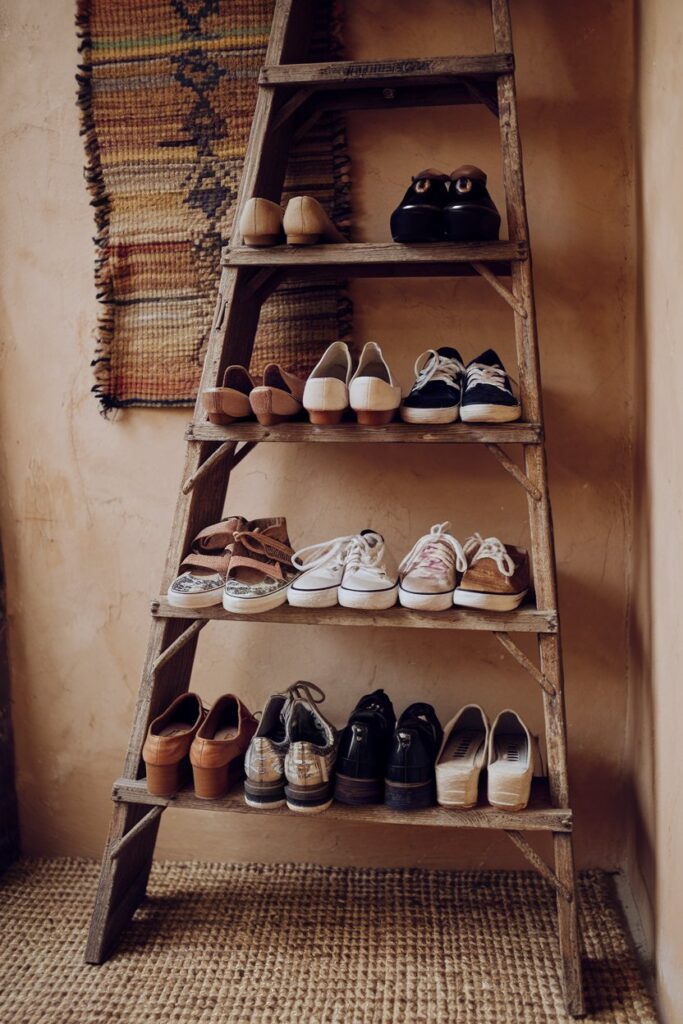 An old wooden ladder leaned against the wall, each rung holding shoes like heels and sneakers.