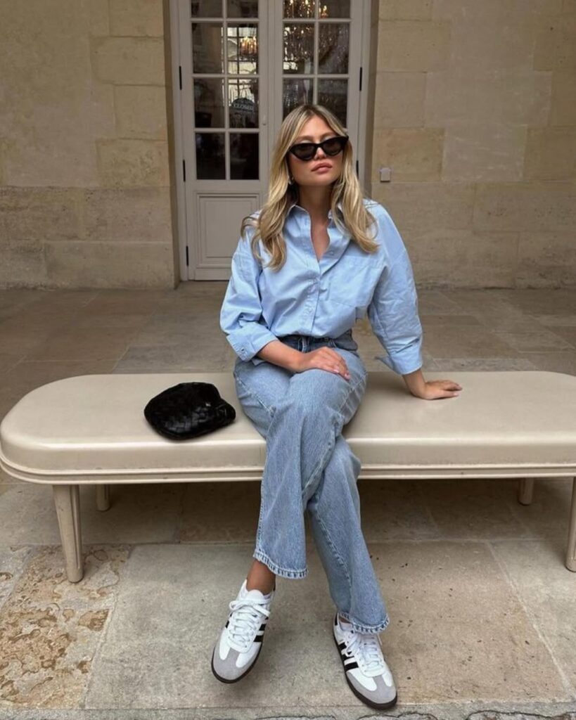 powder blue oversized button-down, half-tucked into a pair of light straight-leg jeans.