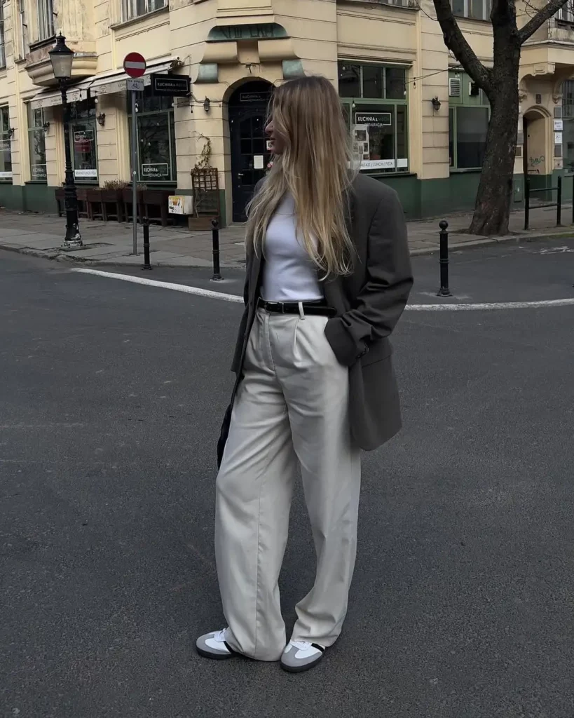 Start with ivory or stone-toned wide-leg trousers and a clean white tank or tee, then layer on a slightly oversized charcoal or dark olive blazer for a sharp finish.