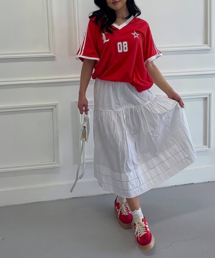 crisp white tiered cotton midi skirt, then layer on a bold red soccer jersey-style tee. Finish the look with matching red Adidas Sambas