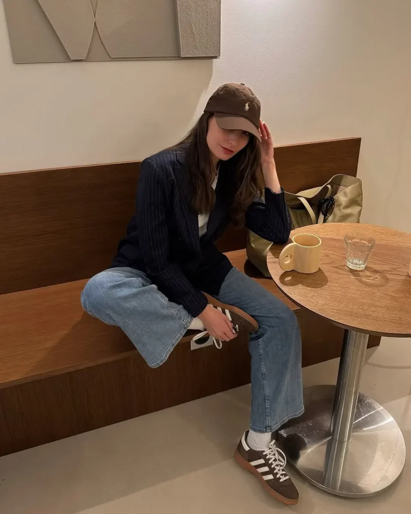 Blend smart and casual by pairing a dark pinstripe blazer with relaxed wide-leg jeans. Finish the look with brown Adidas Handball Spezials,