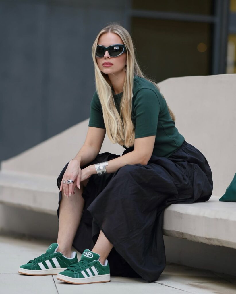A fitted forest green tee meets a flowy black midi skirt, letting the emerald green Adidas Campus 00s shine through as the style ancho
