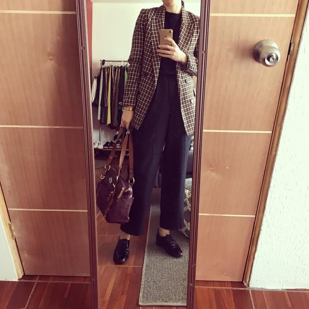  A brown plaid blazer adds structure and a classic pattern, layered over a black top for a sleek base.