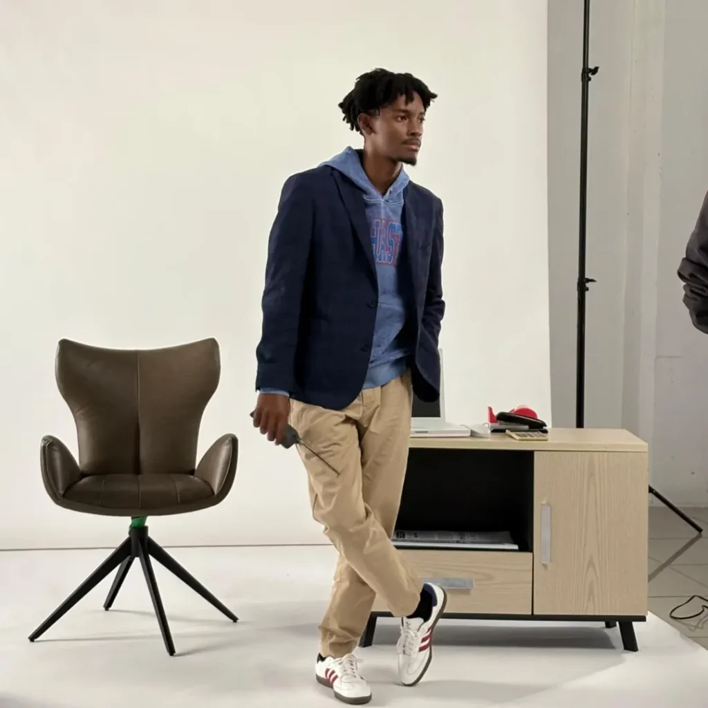 This outfit nails modern layering: a graphic hoodie adds comfort, a navy blazer brings structure, and beige chinos keep the palette light.