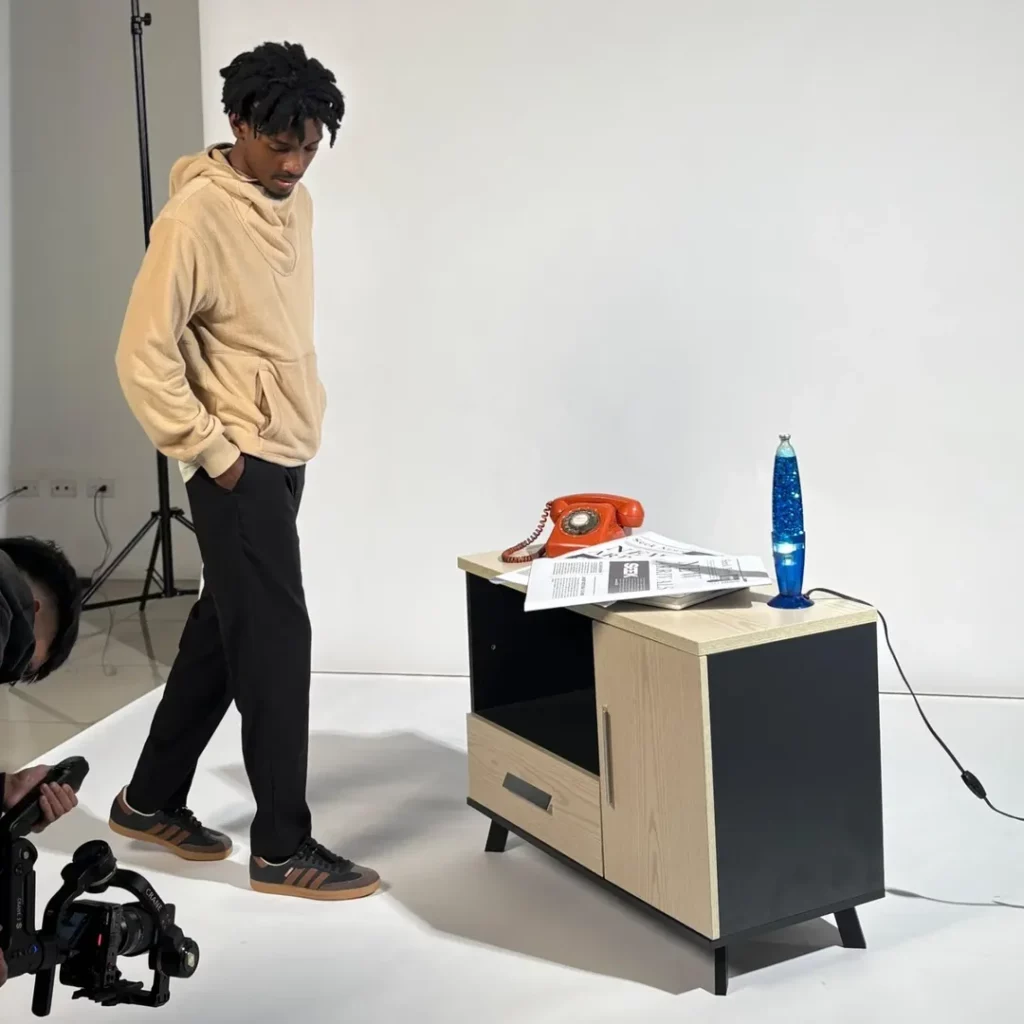 The soft beige hoodie adds warmth and coziness, while the black pants keep things sleek. Brown-stripe Adidas Sambas tie