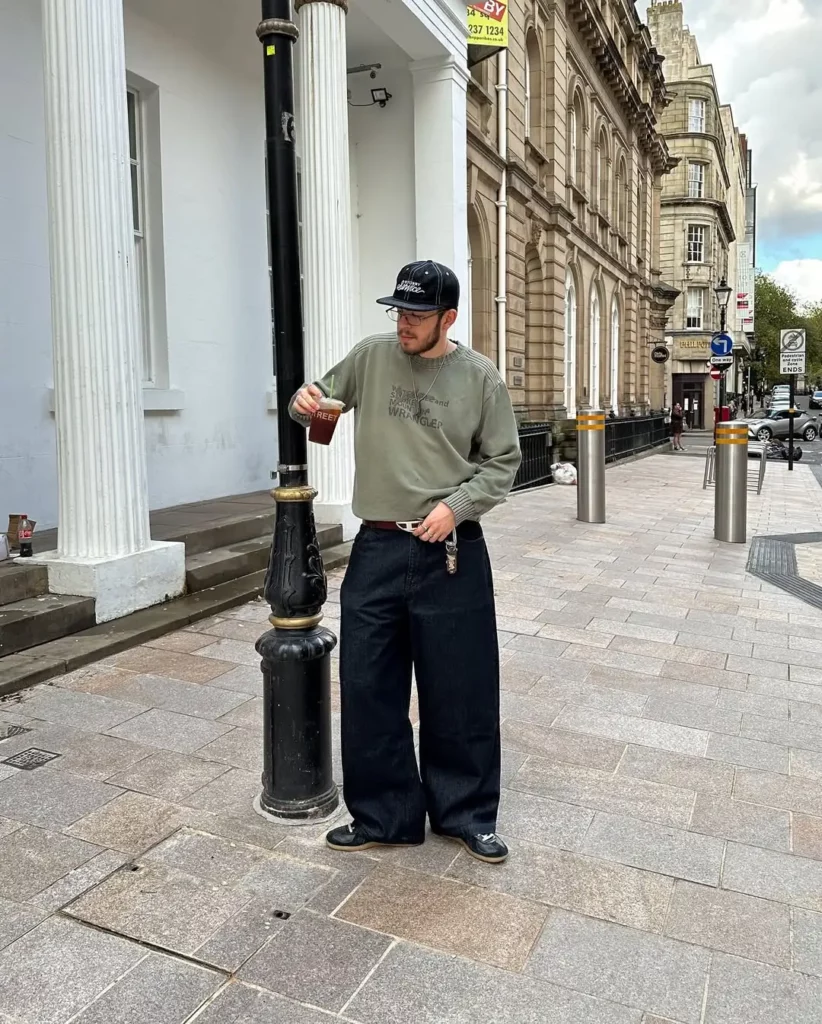The dark wide-leg jeans make a bold silhouette, and the washed-out olive sweatshirt keeps it muted but cool.
