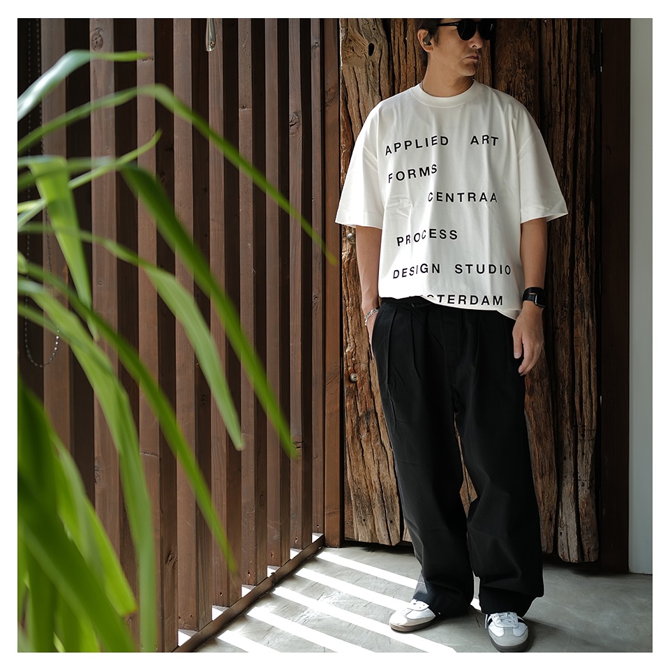 The oversized graphic tee adds visual interest without shouting, while the wide-leg black trousers bring structure and calm.