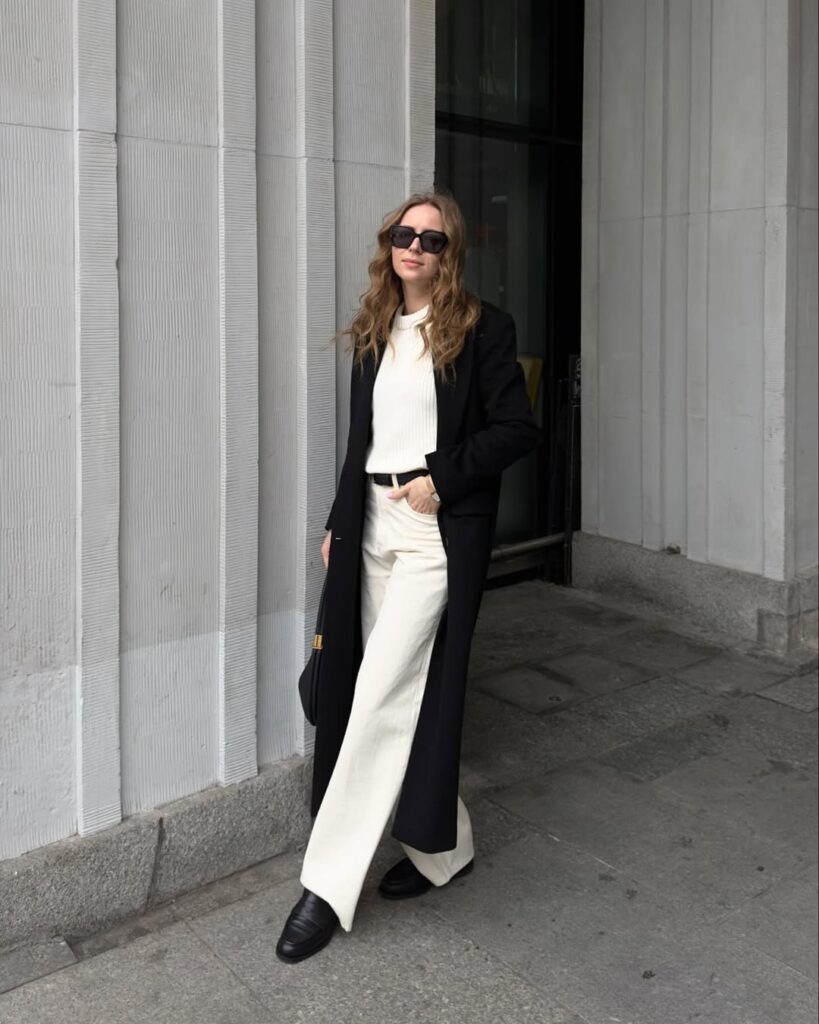 Long Black Coat with Cream Trousers and Classic Loafers