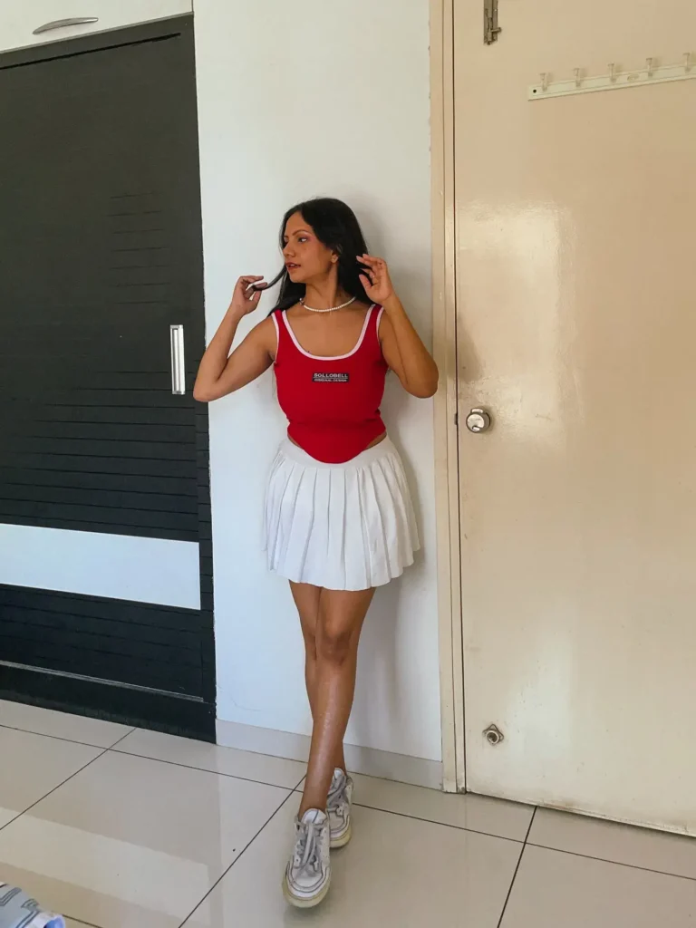 Red Fitted Tank Top with White Pleated Skirt and Sneakers