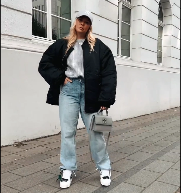Black Bomber Jacket with Light Blue Jeans and Off White Sneakers