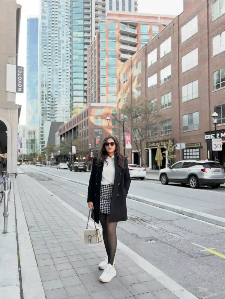 Black Coat and Houndstooth Skirt with White Sneakers